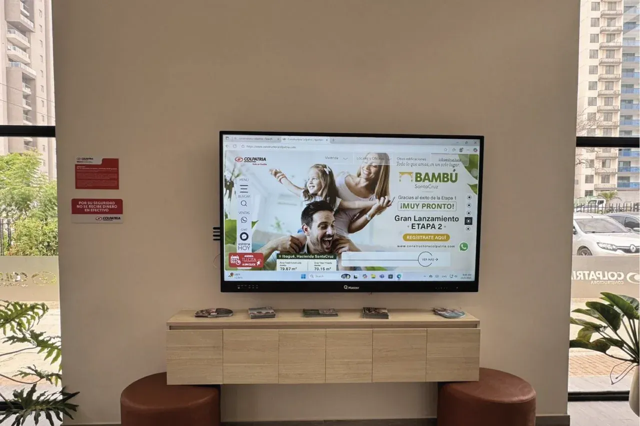 Pantalla interactiva mostrando la pieza de lanzamiento de una etapa del proyecto, sobre el mueble bajo con tabletas de acabados.