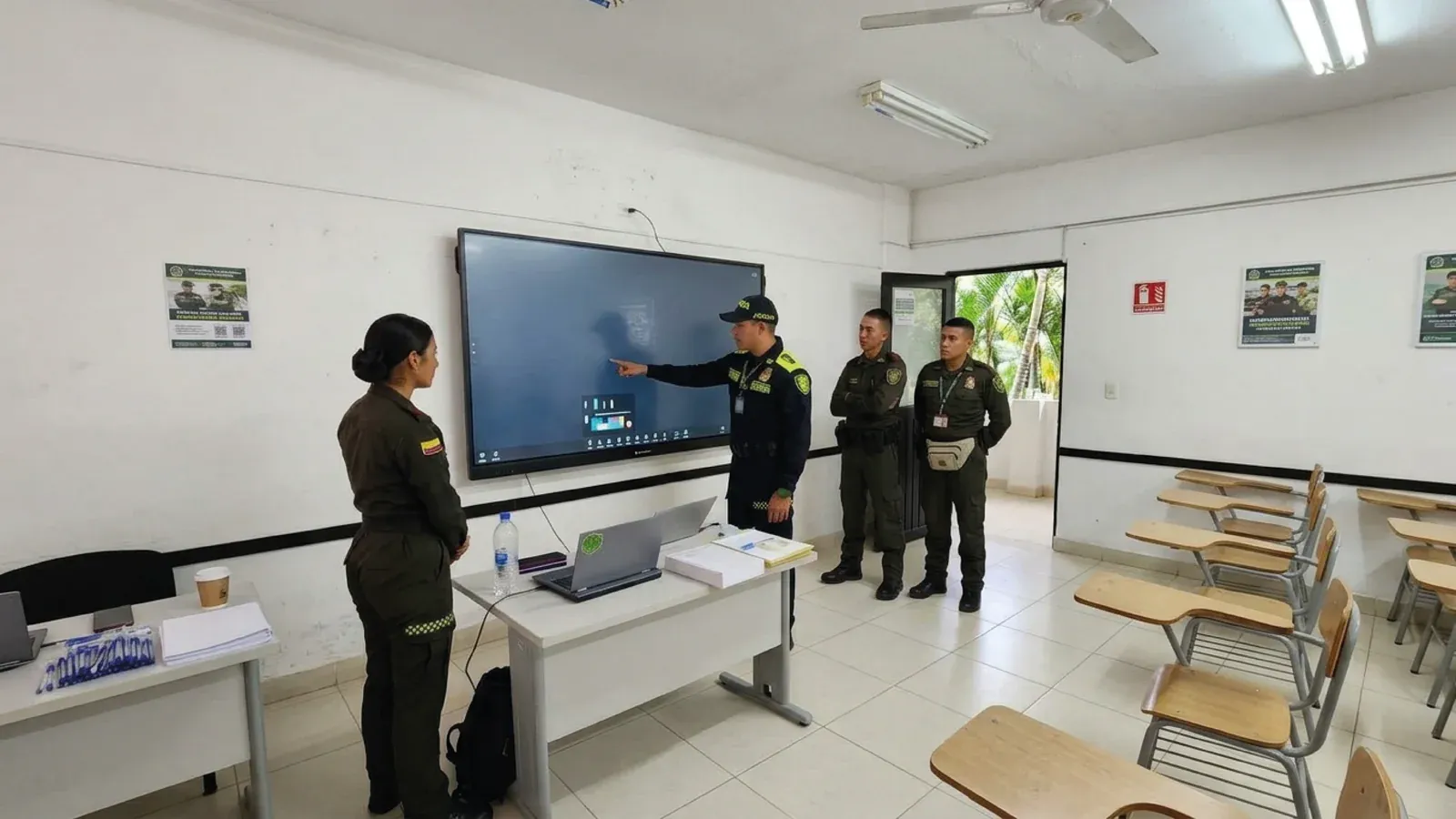Aula de formación de la Policía Nacional: uniformados frente a la pantalla interactiva QMaster encendida.