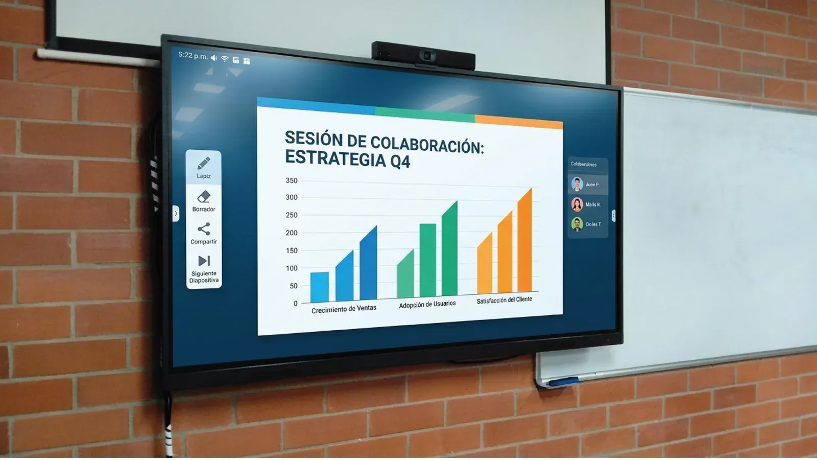Aula de la Universidad de Medellín: pantalla sobre muro de ladrillo con una barra de videoconferencia Yealink montada encima, mostrando una sesión de colaboración.